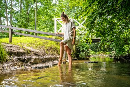 Frau geht durch Wasser in der Natur vom Kurpark Bad Holzhausen