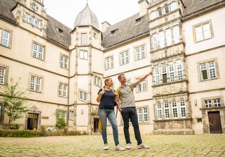 Zwei Personen im Innenhof von Schloss Varenholz, Mann zeigt auf etwas