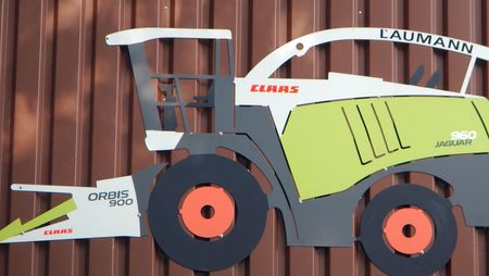 Ein Schild in Form eines Mähdreschers der Firma Claas