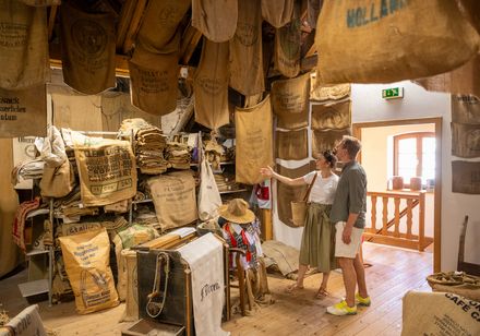 Sackmuseum Nieheim: Zwei Personen blicken in Raum, in dem eine Vielzahl an Jutesäcken hängt