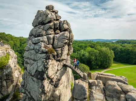 Die Externsteine im Teutoburger Wald, markante Sandsteinfelsen mit Brücke und grüner Umgebung.