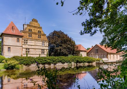 Historisches Gebäude, vorne Wasser und Baum