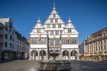 Renaissance-Rathaus mit prächtiger Fassade und Schaugiebeln, im Vordergrund ein runder Brunnen.