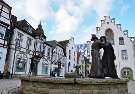 Historische Altstadt mit Fachwerkhäusern und einem Brunnen samt Figurenensembles.