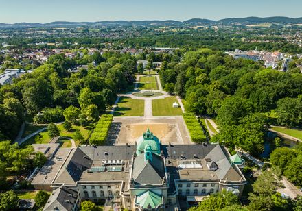 Luftaufnahme des Kaiserpalais in Bad Oeynhausen, eingebettet in eine grüne Parklandschaft.