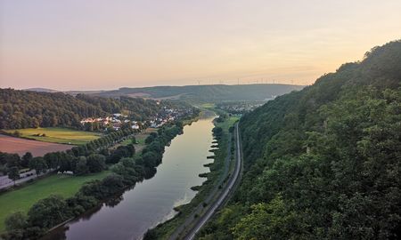 Abendlicher Ausblick vom Weser-Skywalk auf Fluss, Wälder und Felder der umliegenden Landschaft.