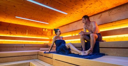 Zwei Personen in einer beleuchteten Sauna