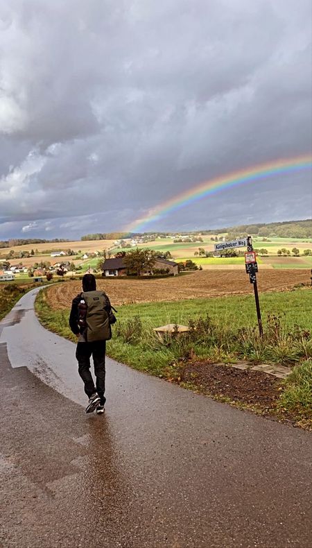 Wanderer vor Regenbogen im Eggetal