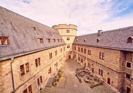 Innenhof der DJH Jugendherberge Wewelsburg mit historischem Mauerwerk und zentralem Rundturm.
