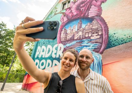 Paar macht Selfie vor dem Herzgraffiti in Paderborn