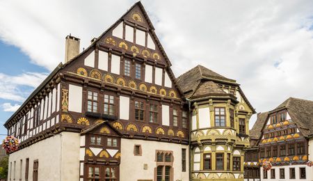 Mit Zierelementen im Stil der Weserrenaissance reich verzierte Fachwerkgebäude, im Vordergrund die Dechanei