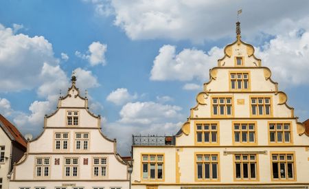 Historische Gebäude mit aufwendigen Giebeln in Lemgo, unter wolkenbedecktem Himmel.