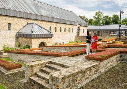 Zwei Personen bei Blumebeeten bei dem LWL-Museum in der Kaiserpfalz Paderborn